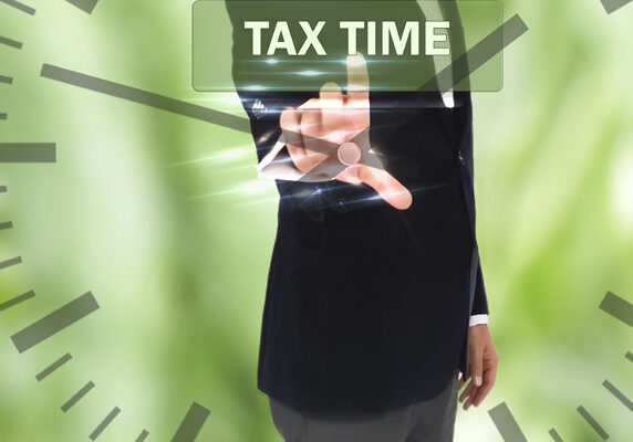 business, technology, internet and networking concept - businessman pressing tax time button on virtual screens and clock, blurred of green nature outdoor bokeh background